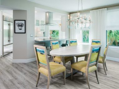 Six-seat dining room with chandelier and open counter to kitchen area