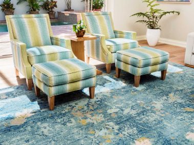 Family room with seating, footrests, and an open porch door with a pool visible